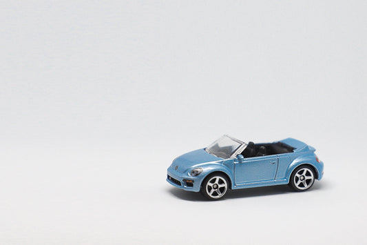a small blue toy car on a white surface
