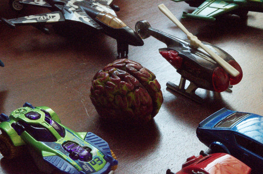 Toy cars and a walnut on a wooden surface
