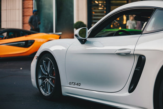White and orange sports cars parked on street