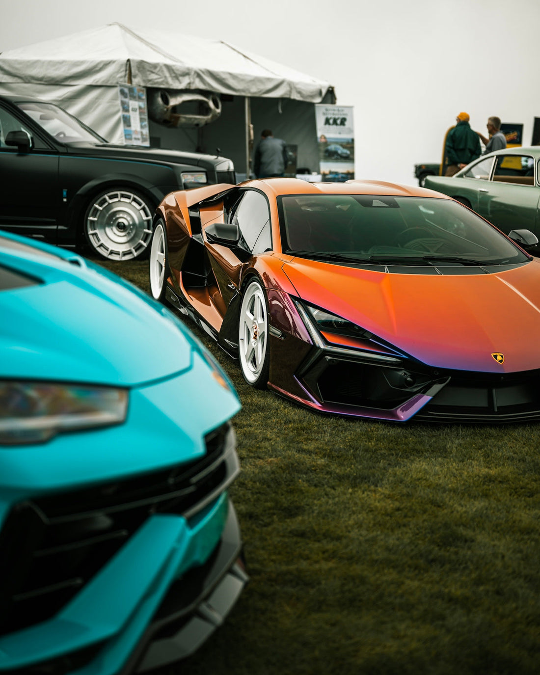Three luxury cars parked on grass